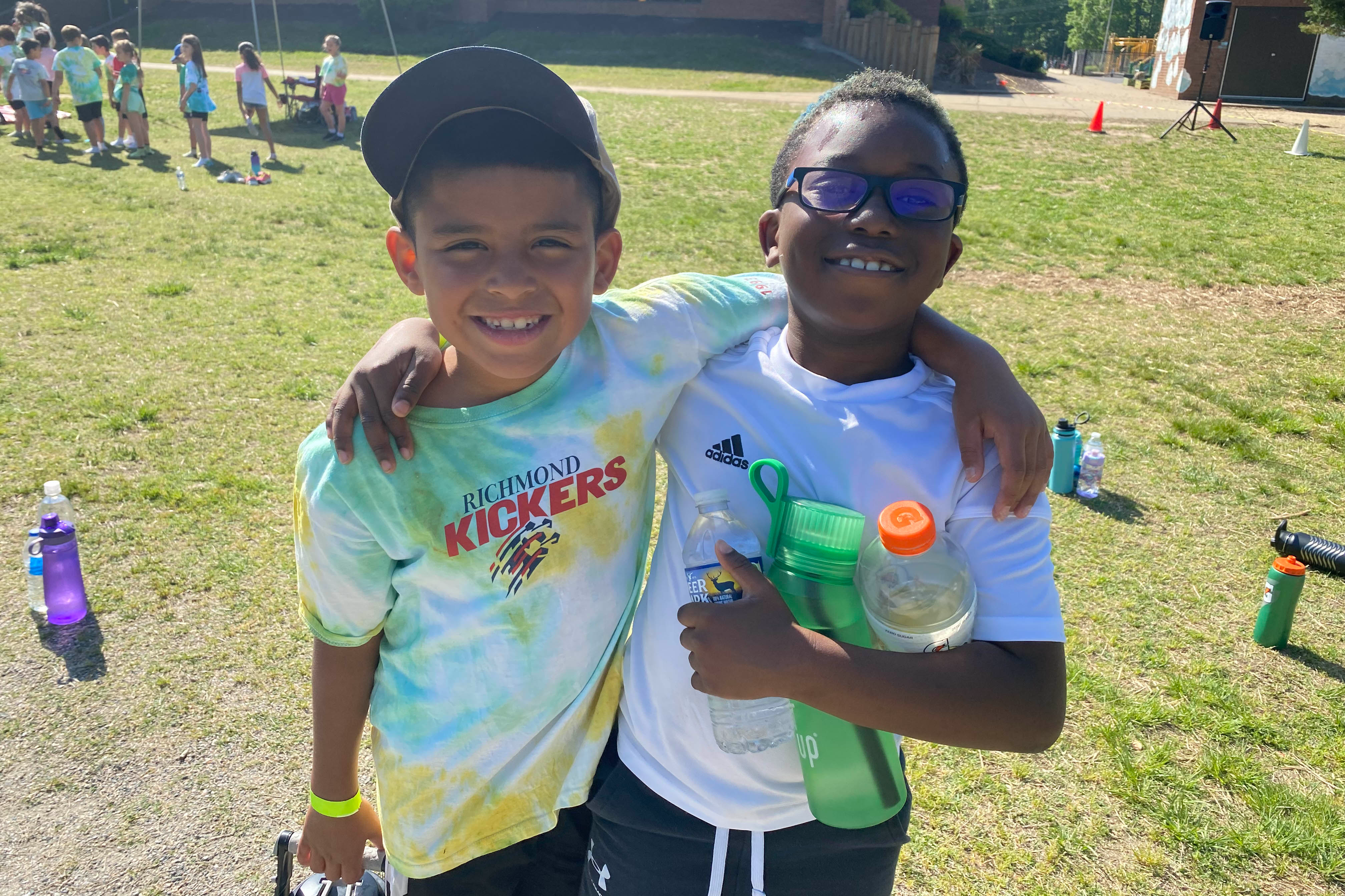 Two students with their arm over the other's shoulder