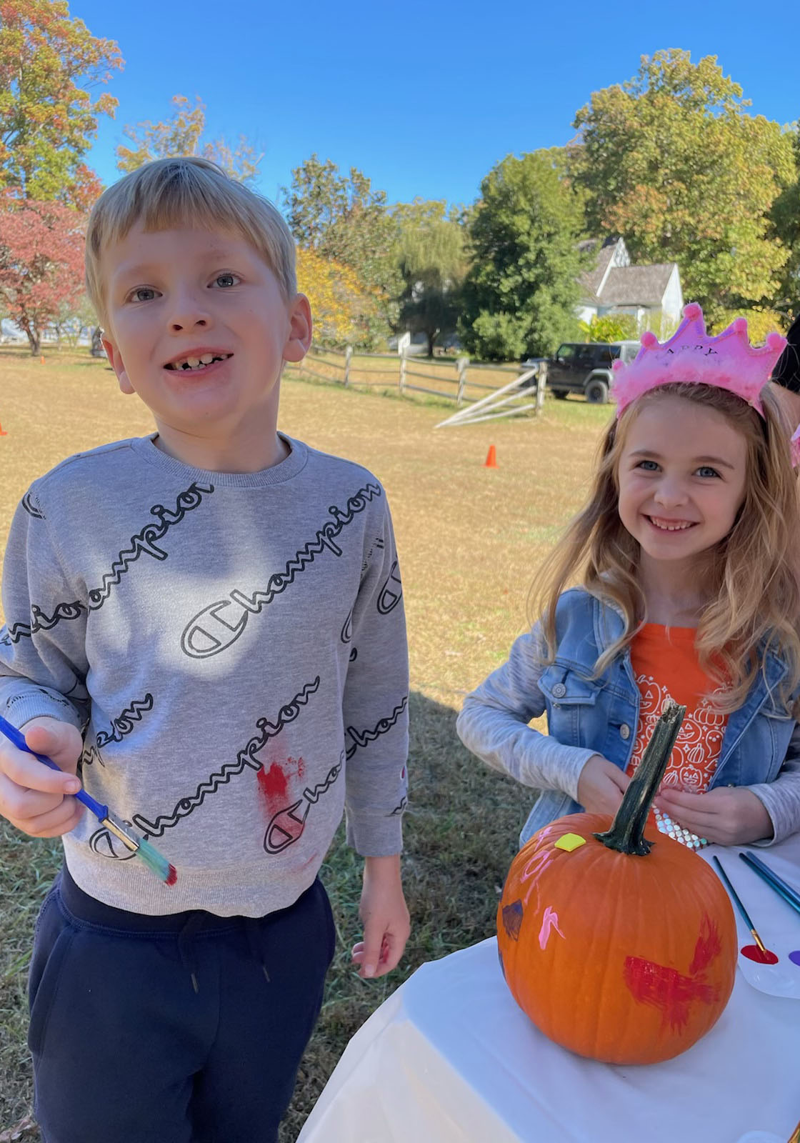 Two students painting a pumpkin