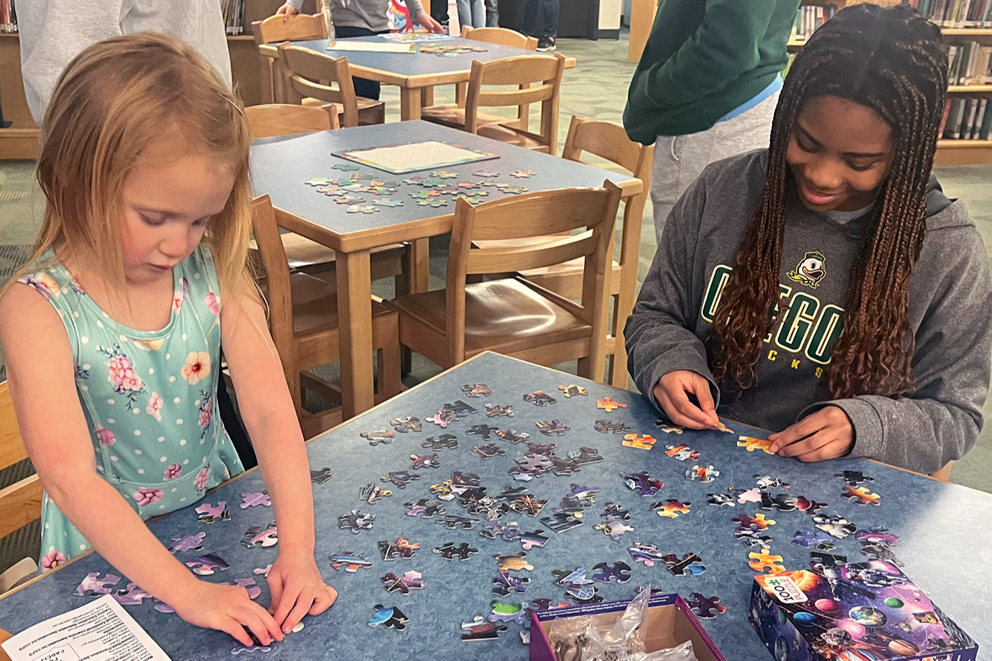 Two students working on a puzzle in the library