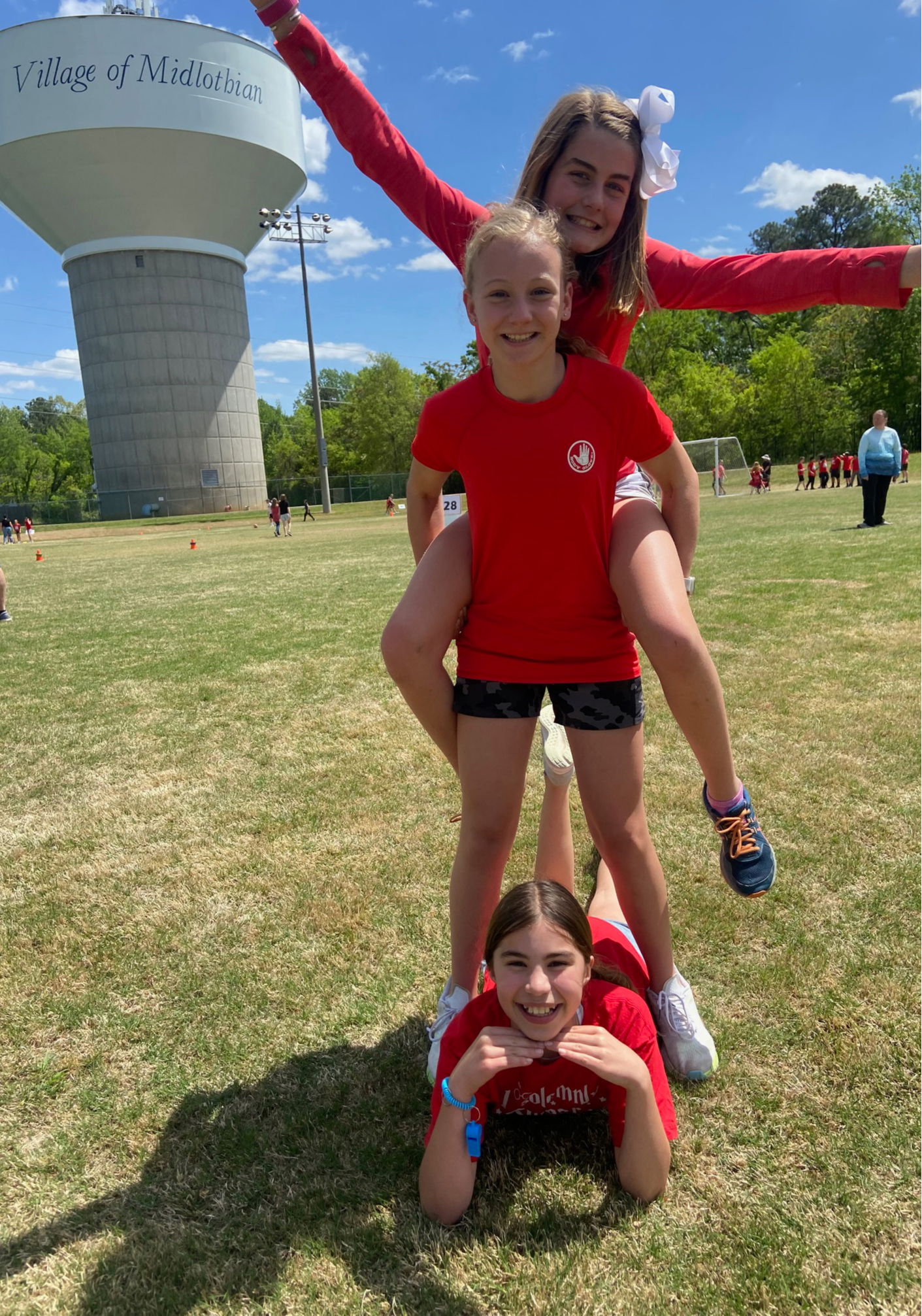 Three girls wearing red shirts pose together for a photo