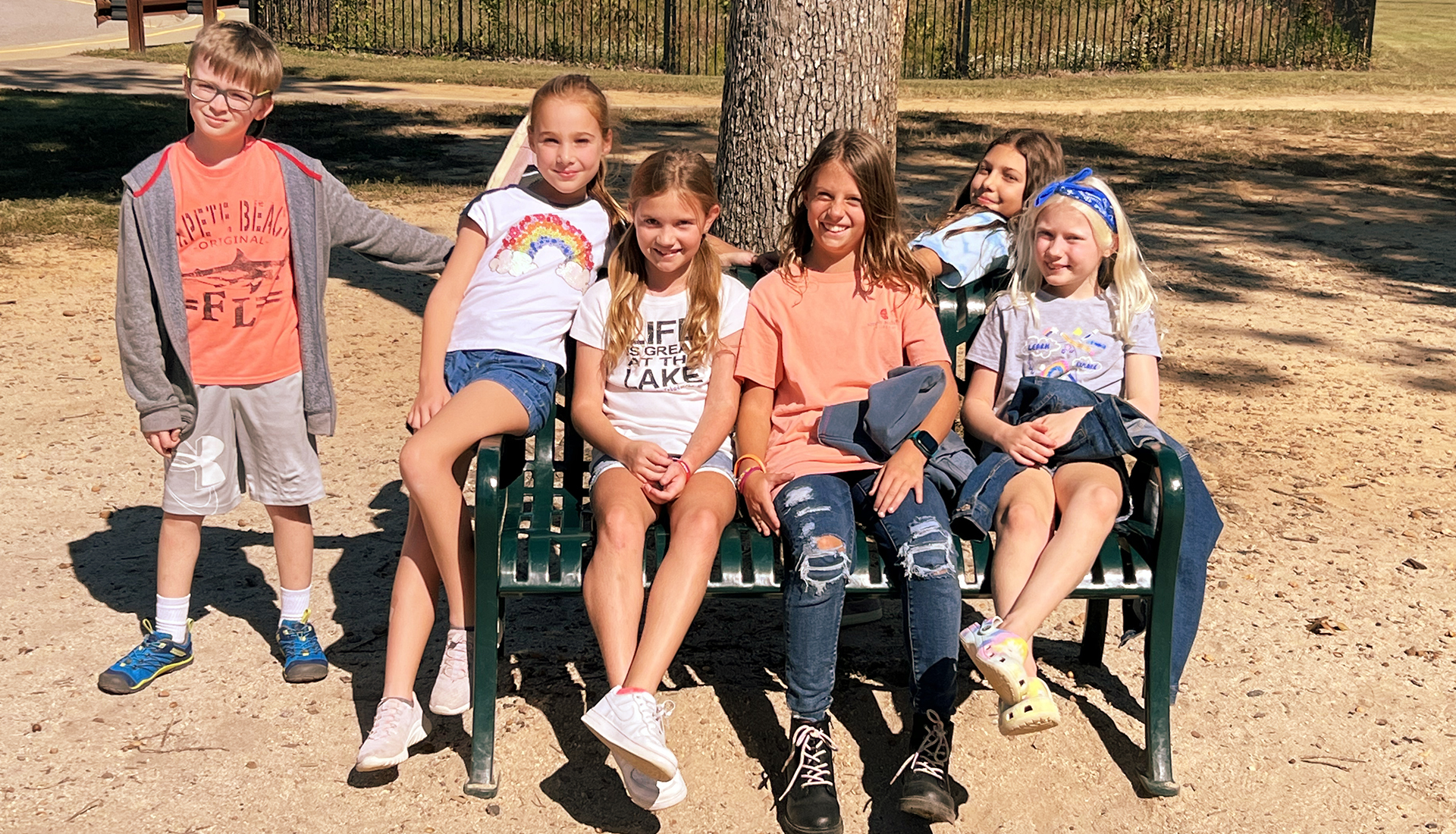 A group of fourth graders sitting outside on a bench