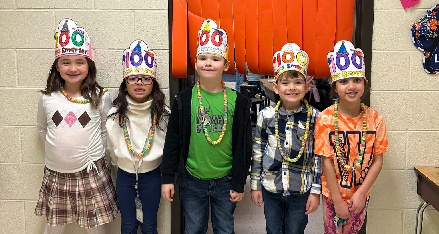 Five students pose in the 100 day crowns they colored.