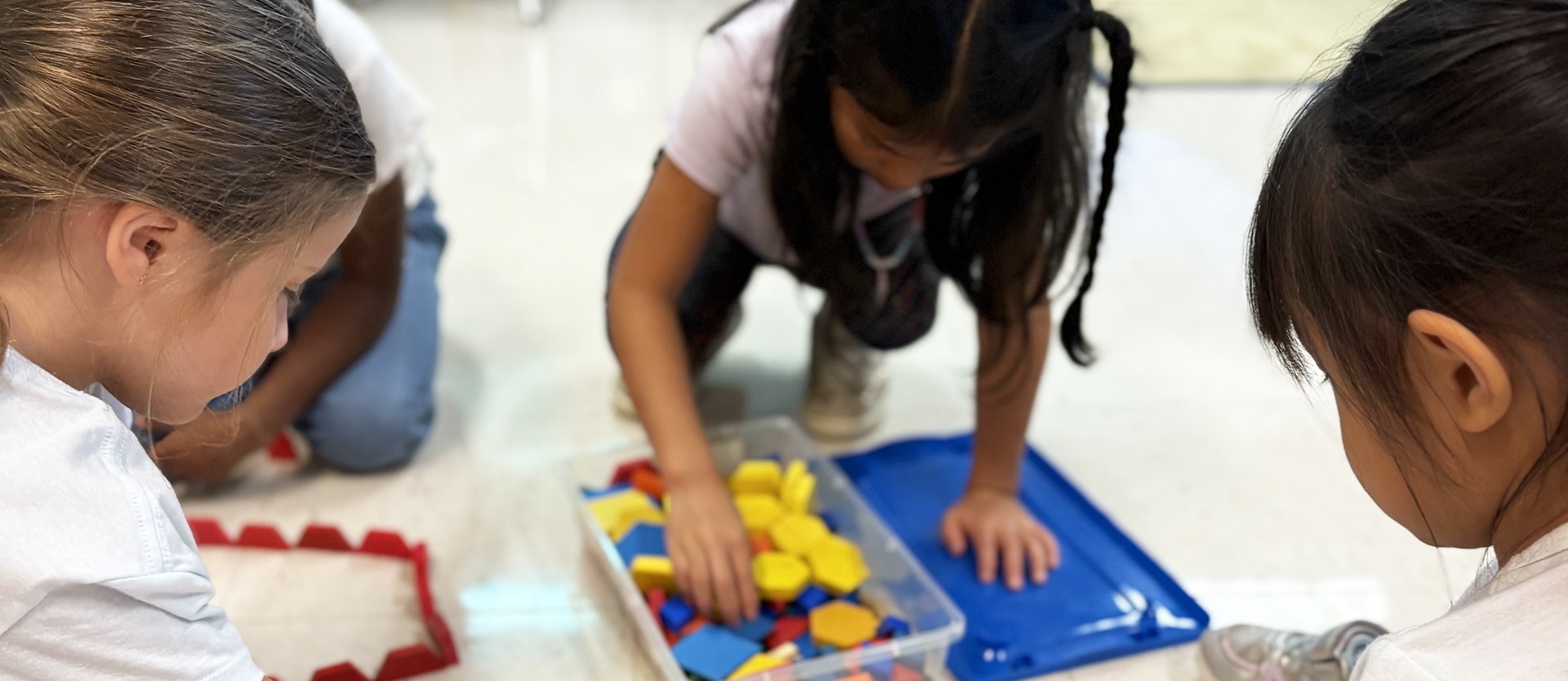 Three students playing on the floor