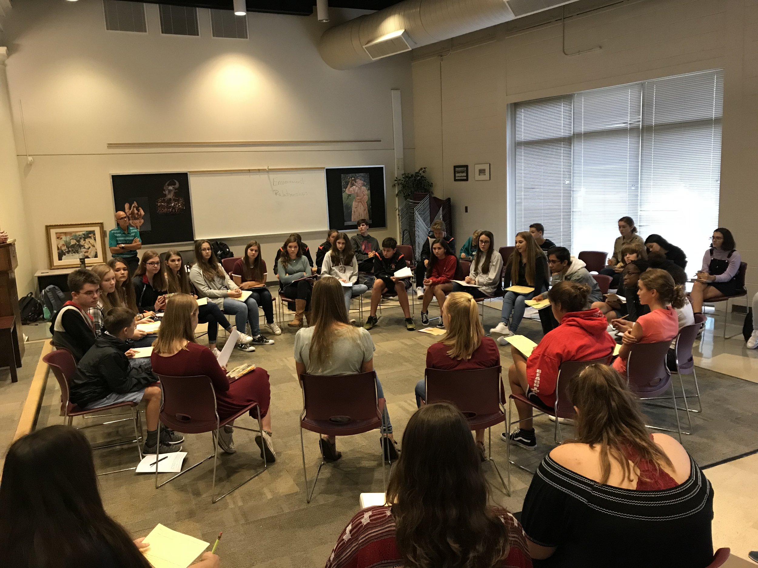Students sit in a circle discussion