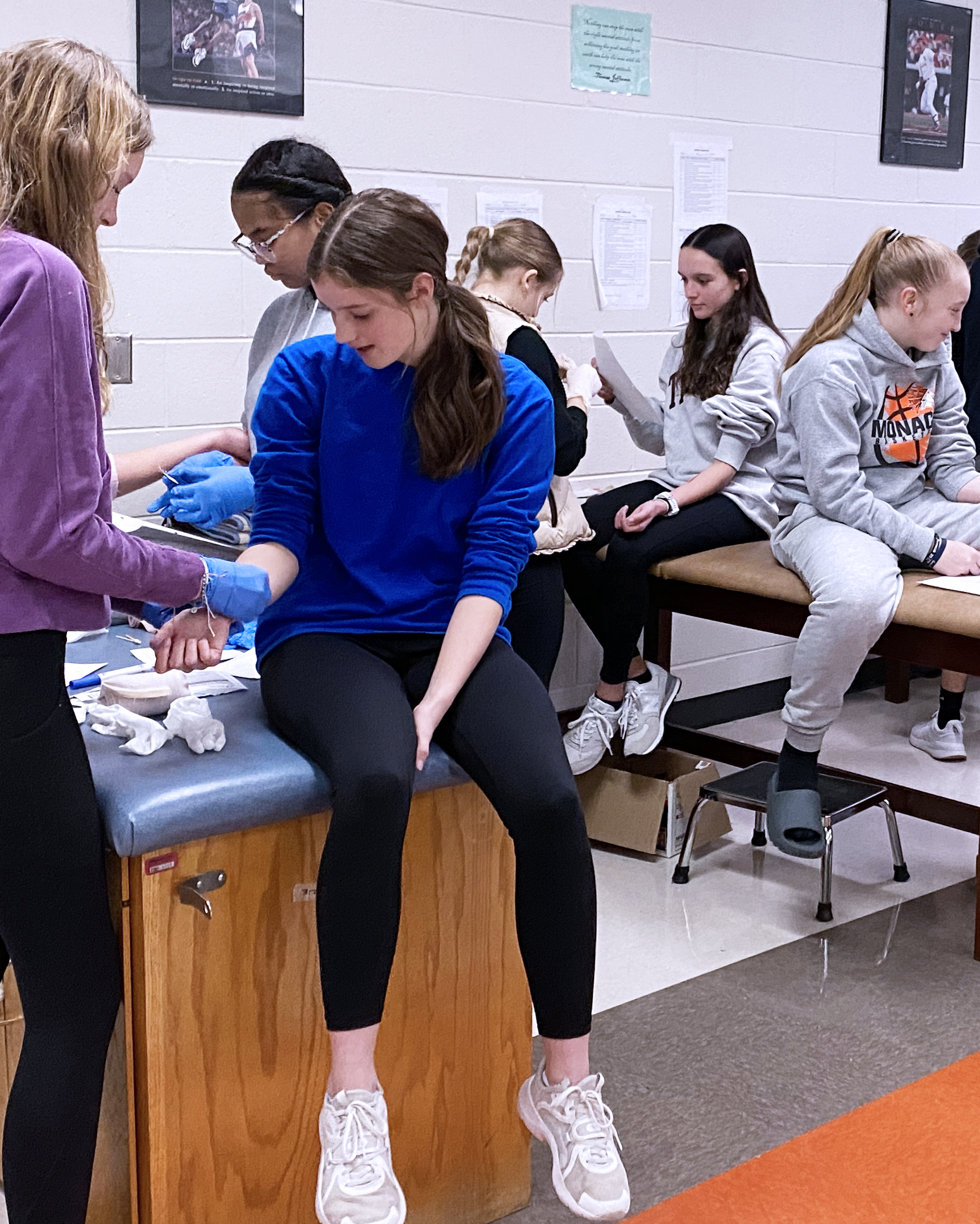 students practicing bandaging each other