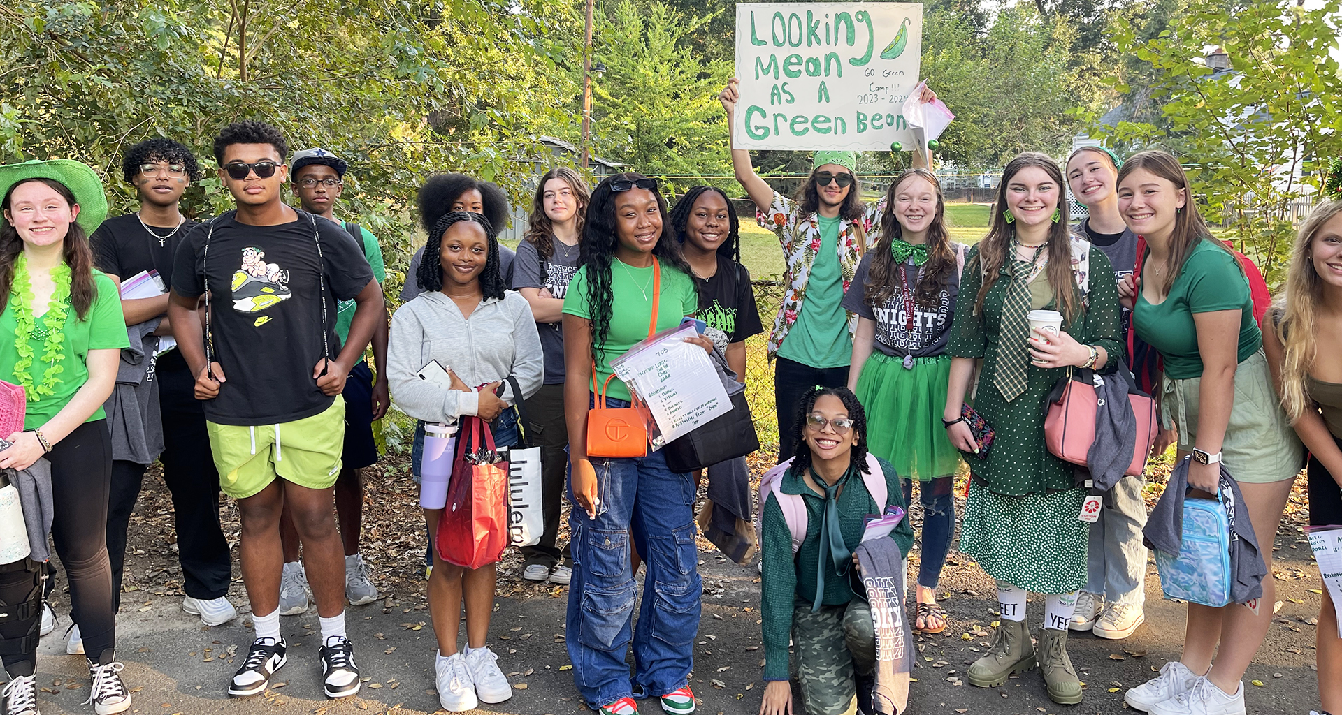 Large group of students dressed in green coming into the school on their first day.