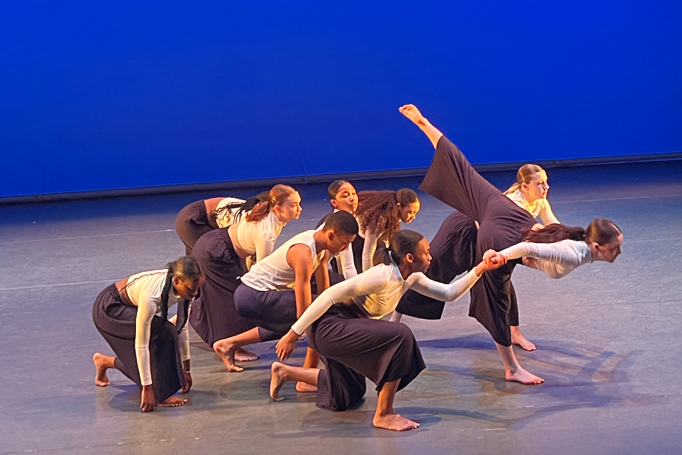 Nine students dance on stage