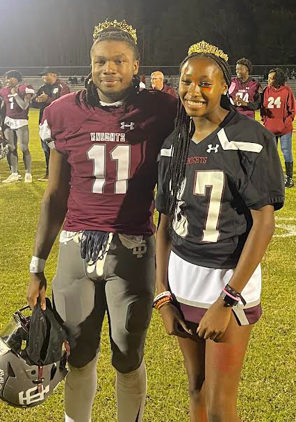King and Queen on football field wearing their crowns.