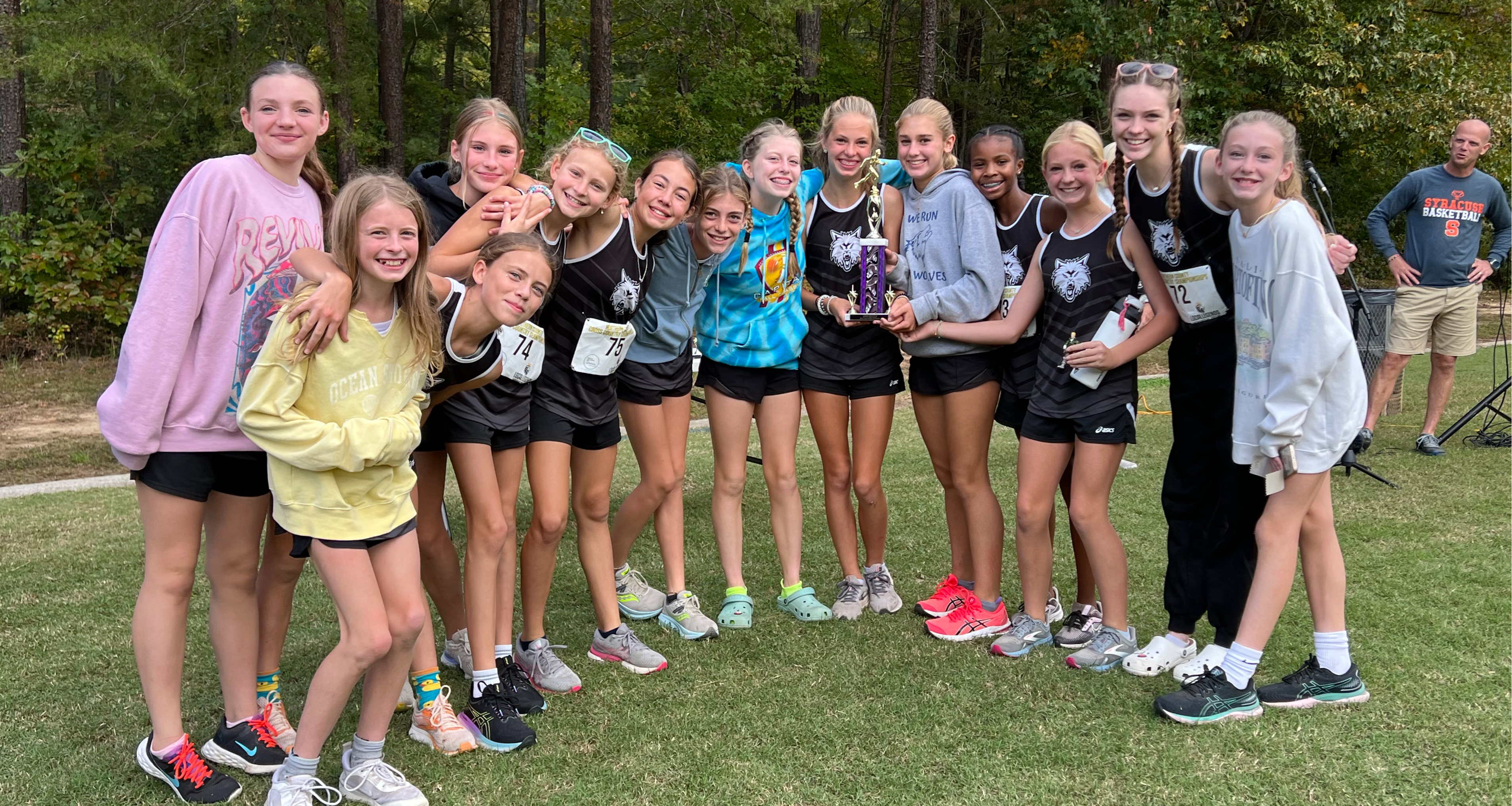 Girls cross country team poses with a trophy