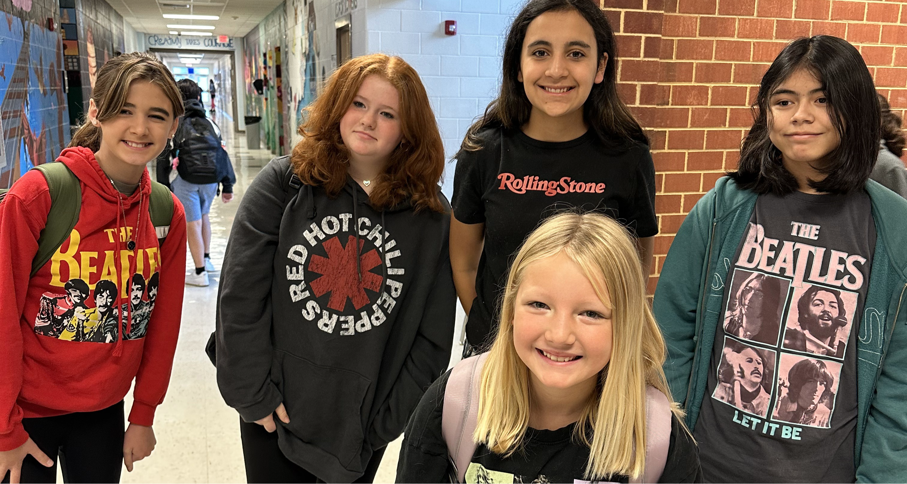 Five girls pose for a photo in the hallway