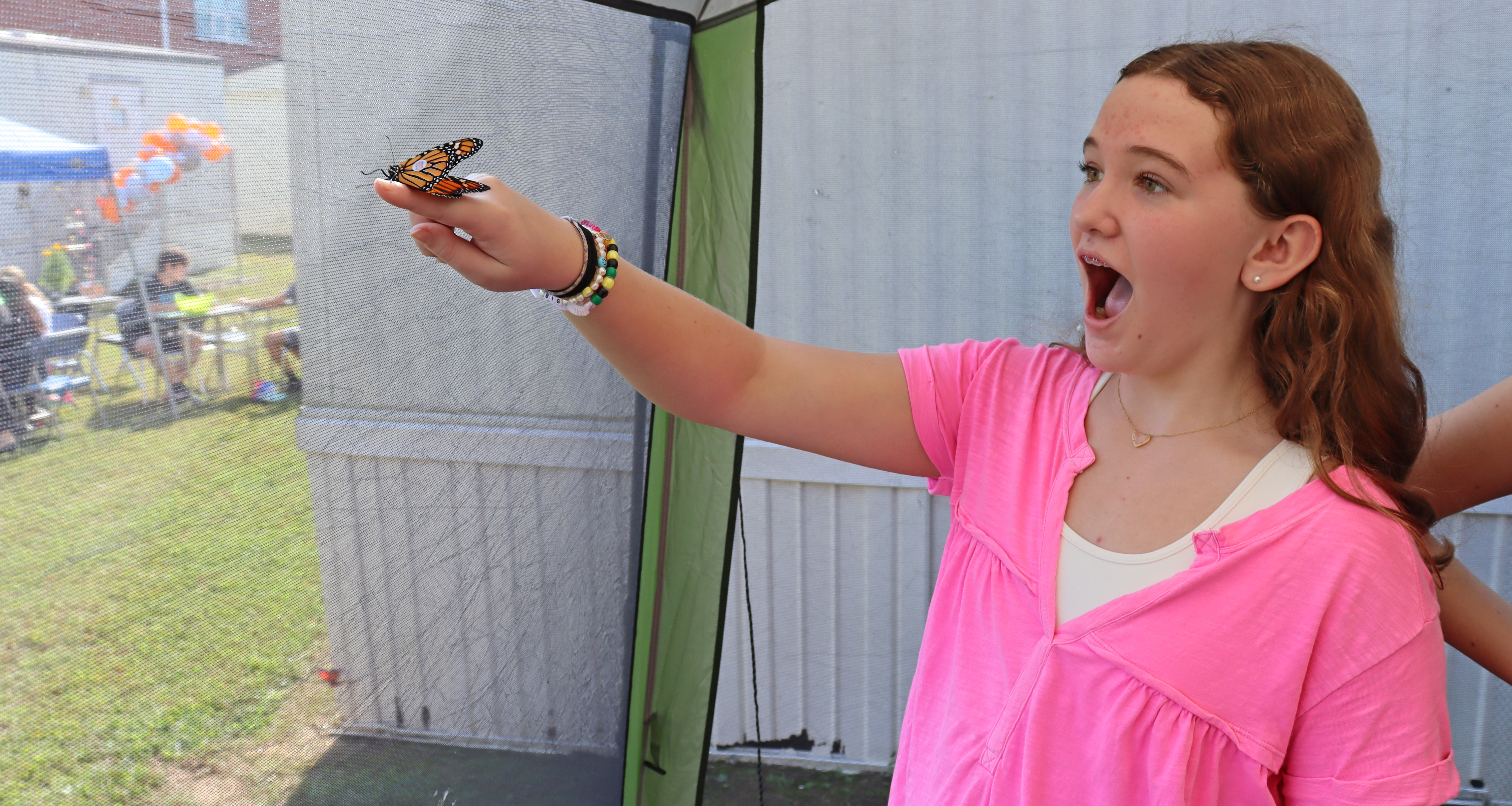 A girl holding a butterfly with her finger