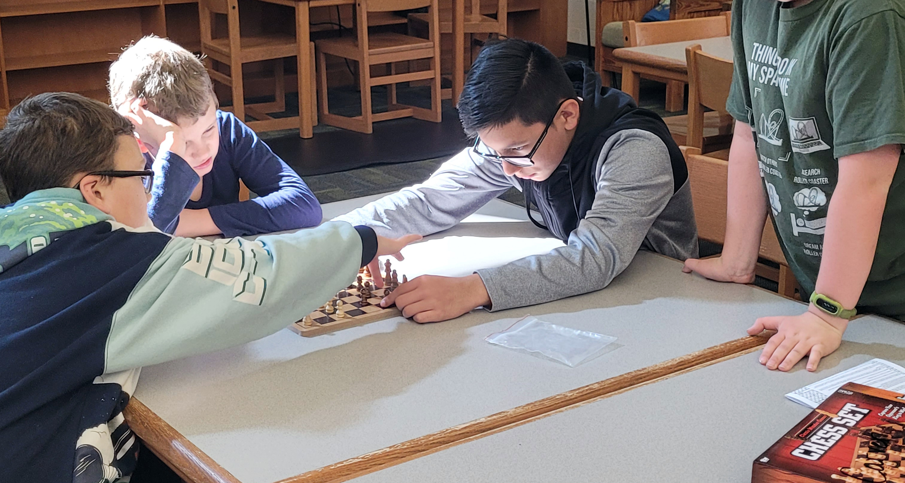Two students playing chess in the school library