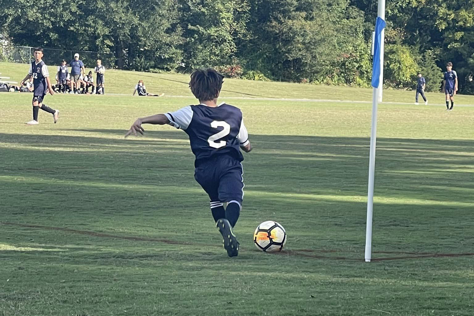 A boy kicking a soccer ball on the field