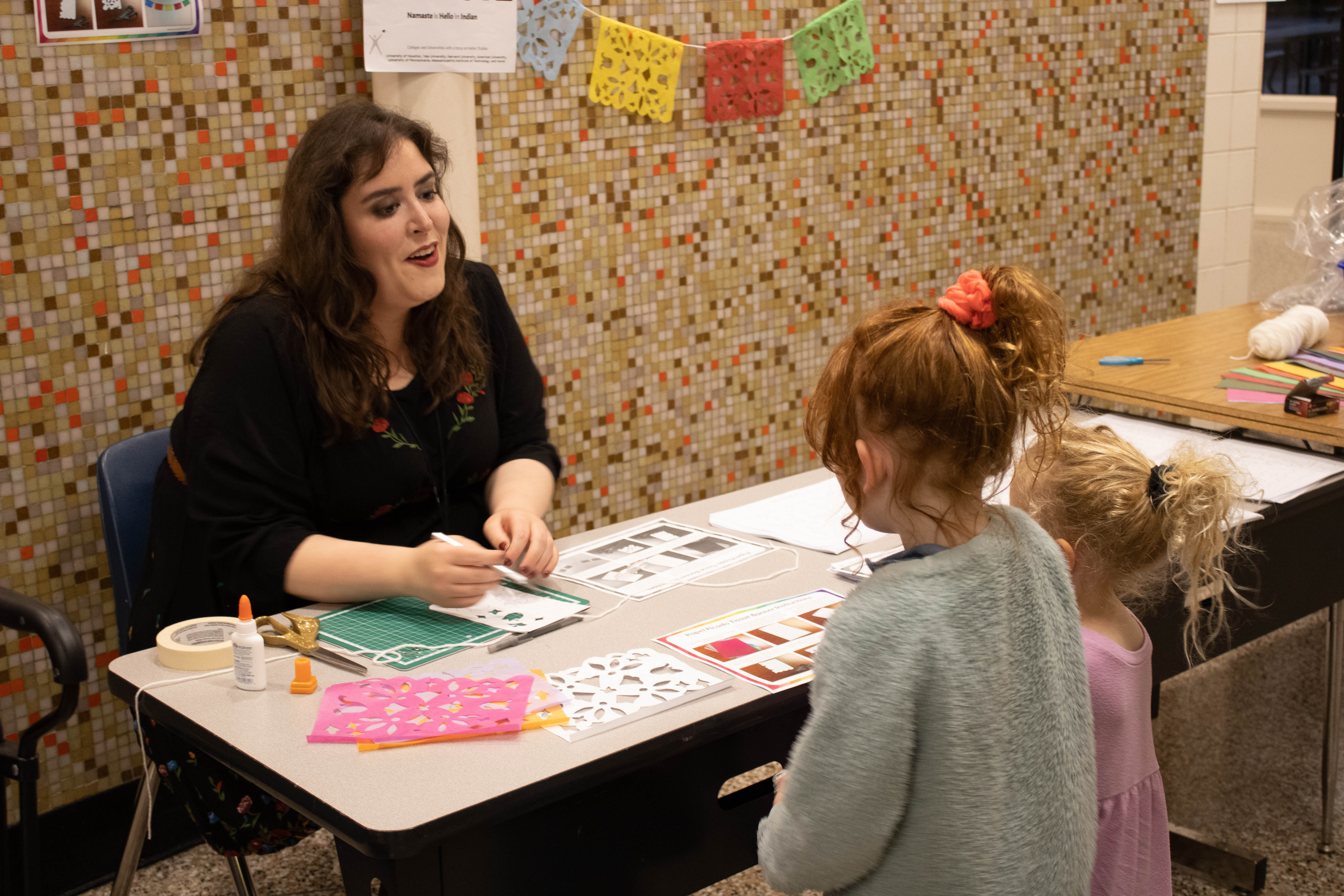 A teacher talking to two students at a table