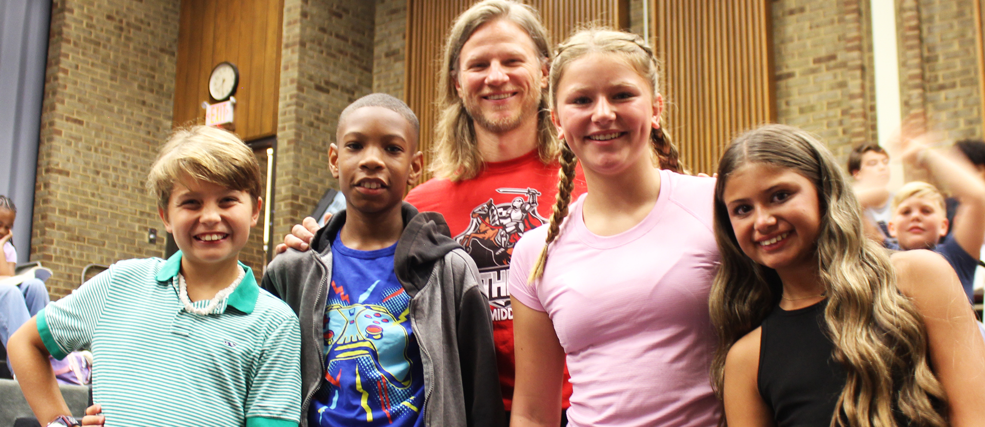 principal poses with four students