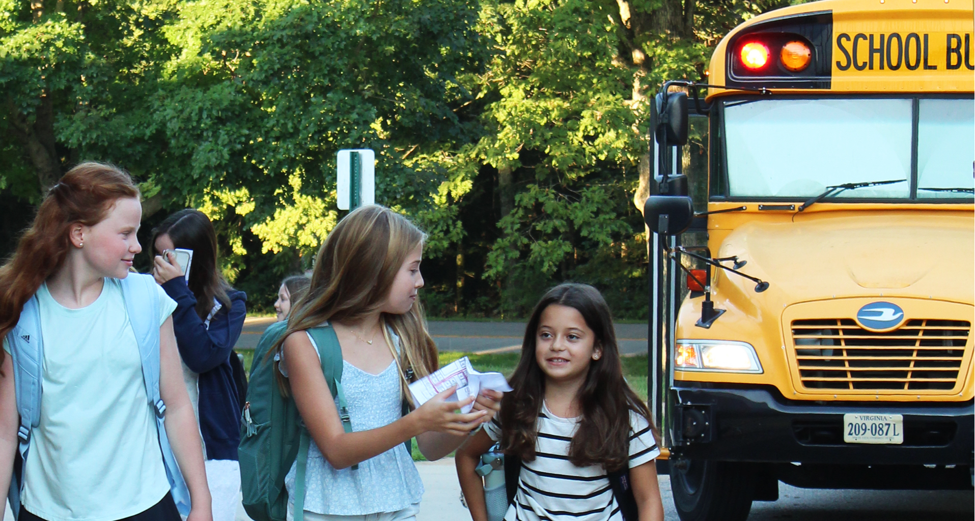 students getting off of the school bus