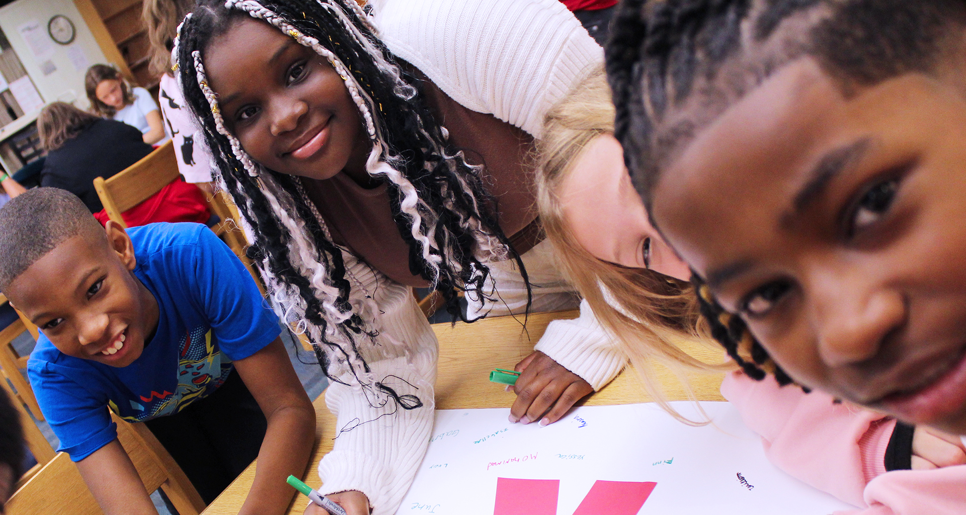 Four students working on a poster