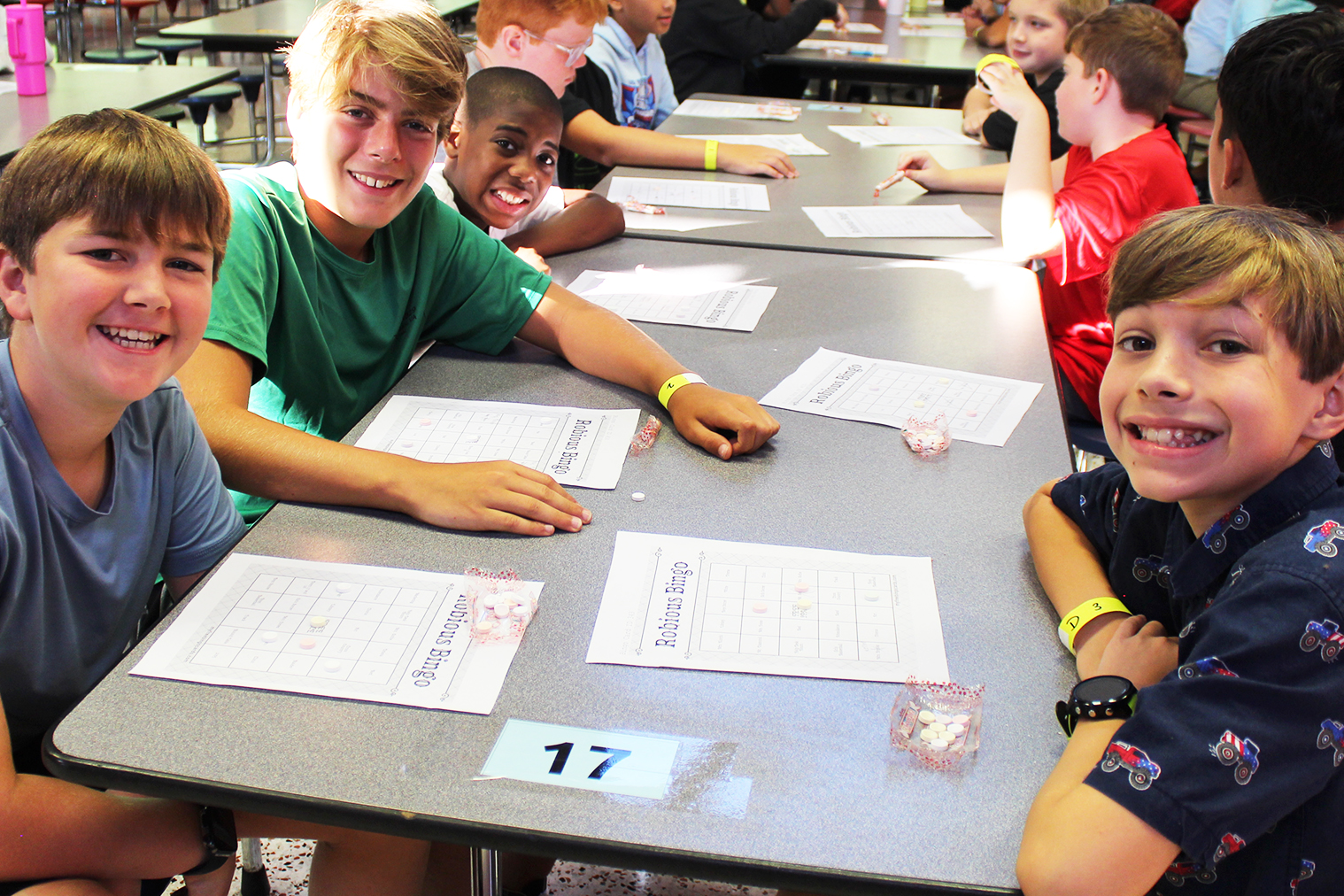 Several students at a table smile for the camera.