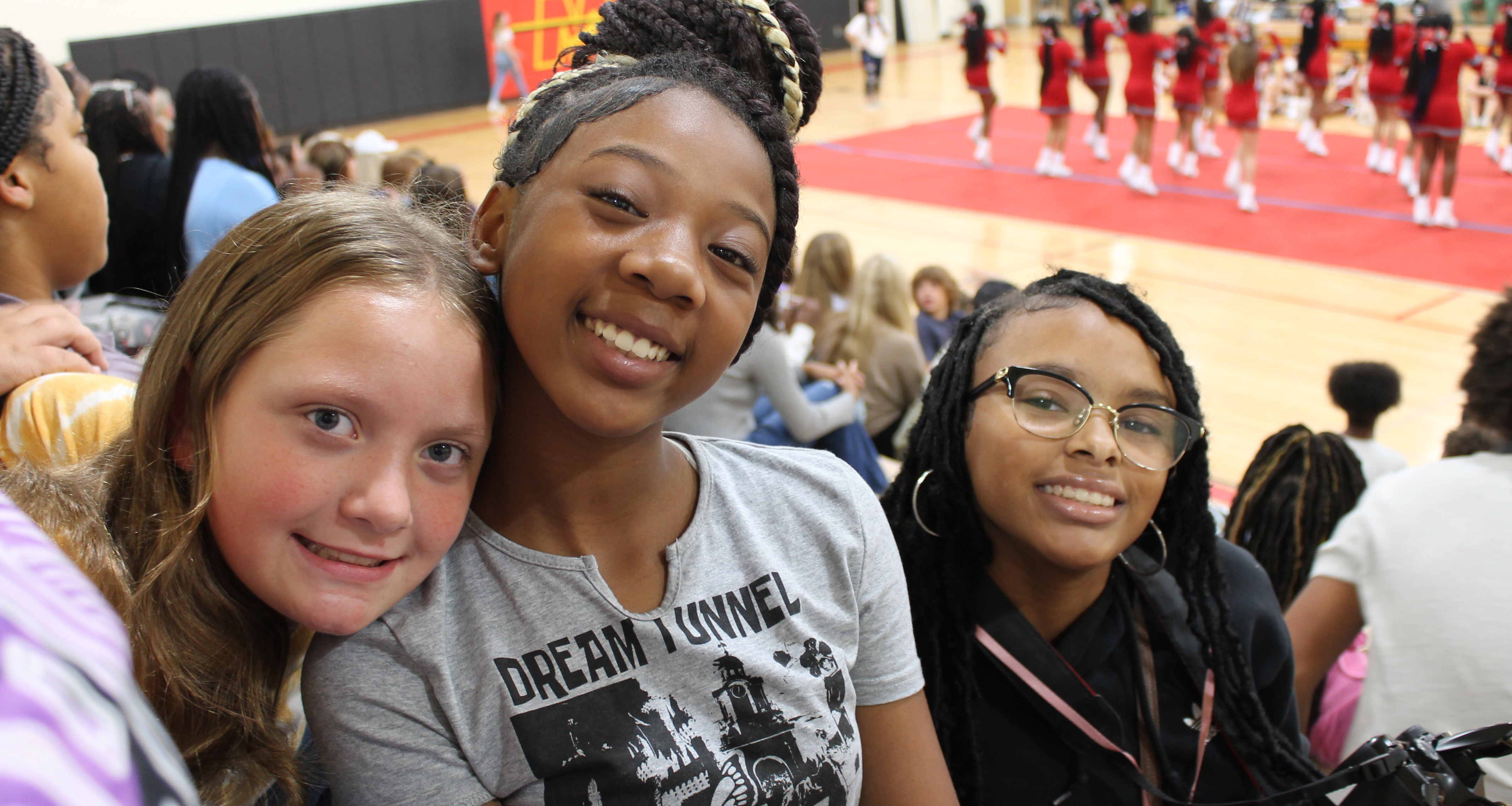 Three girls smiling during a pep rally