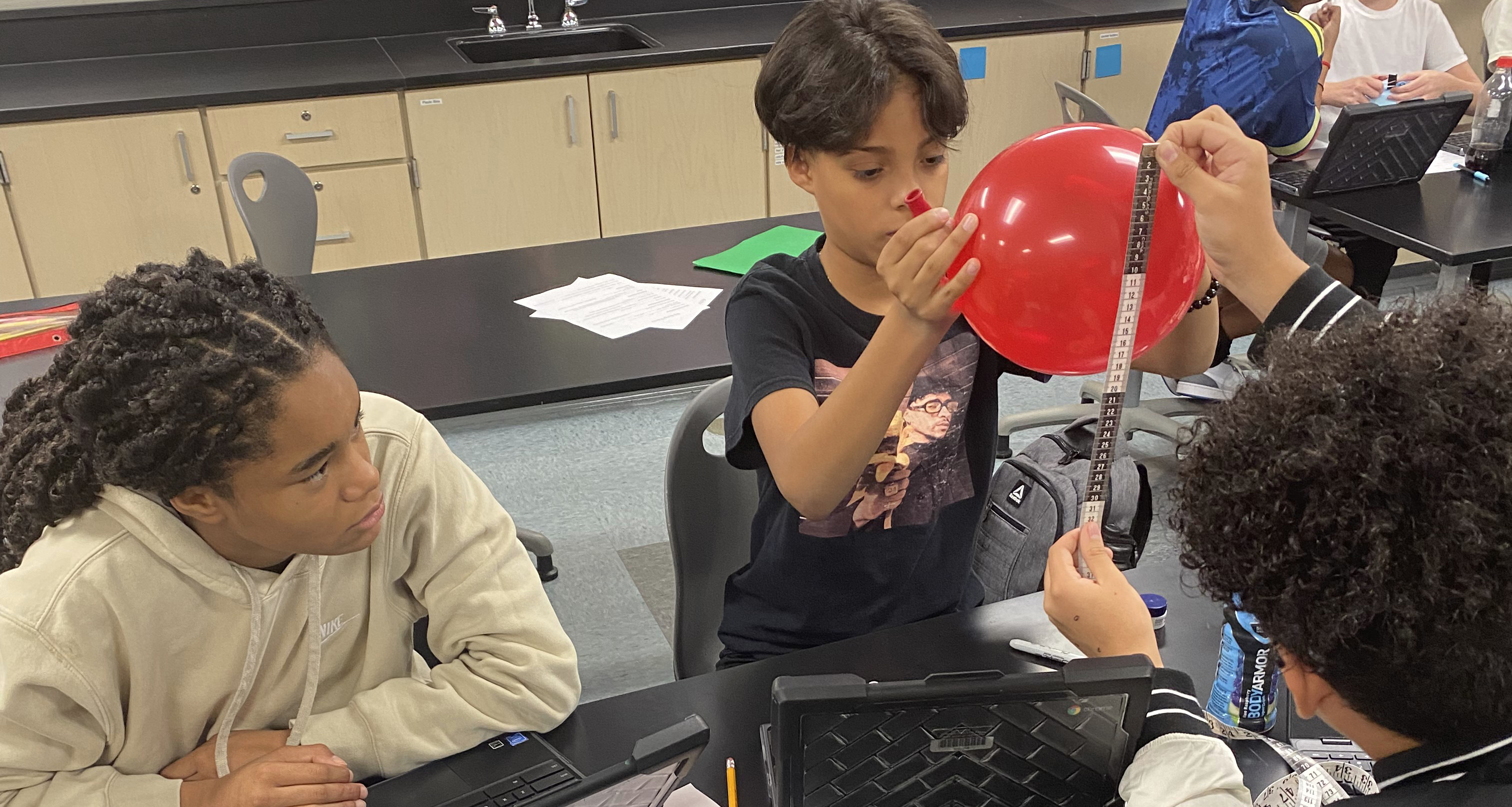Students doing a science experiment with a balloon