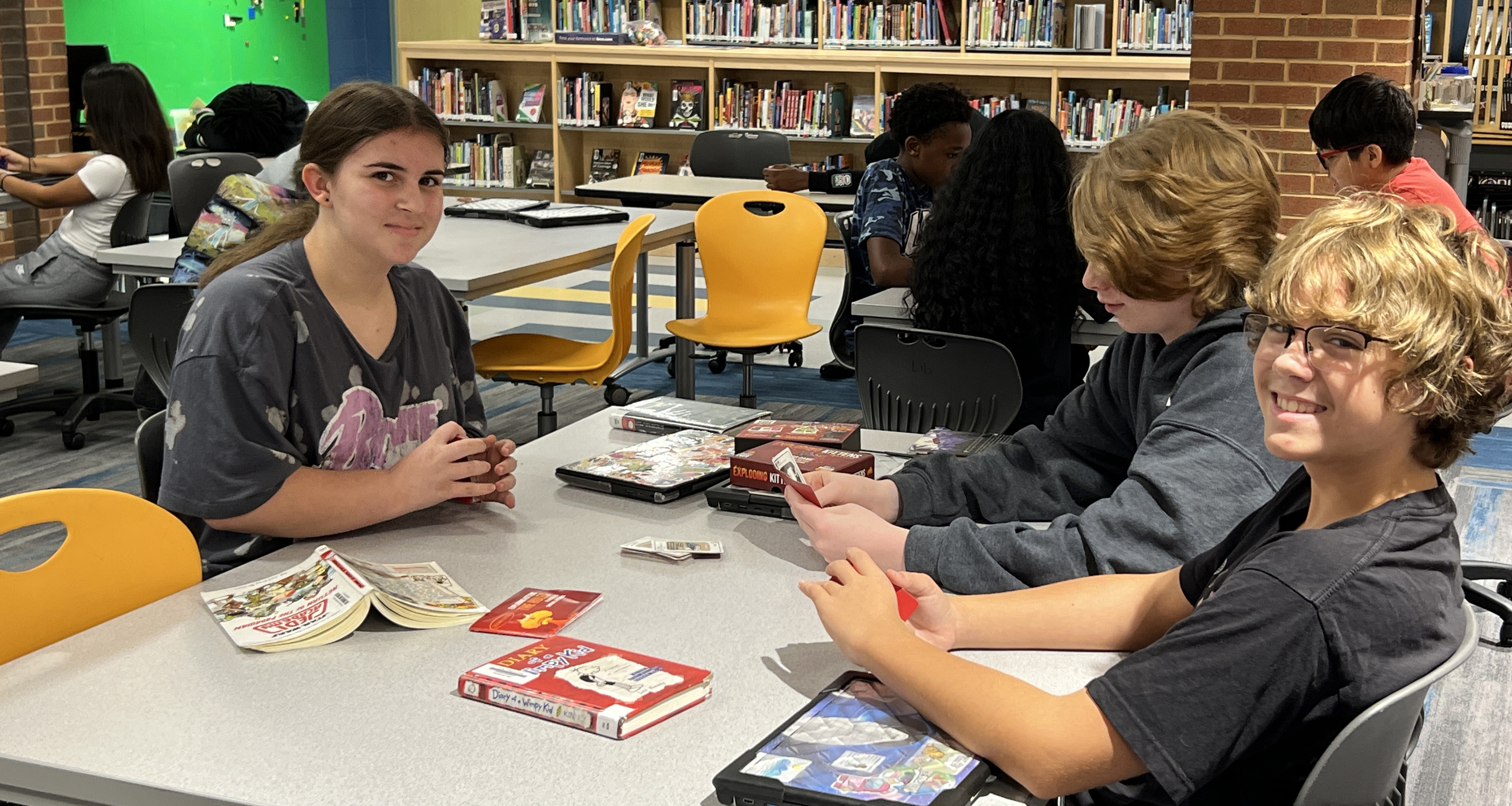Students playing a card game in the school library