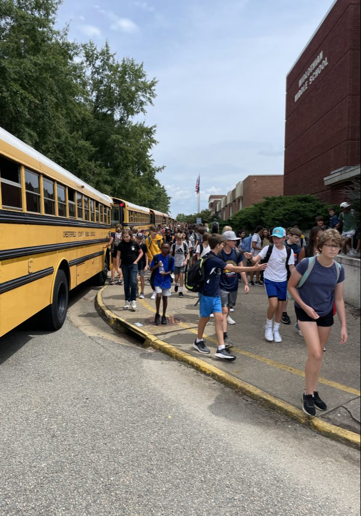 A large group of students getting off of their busses