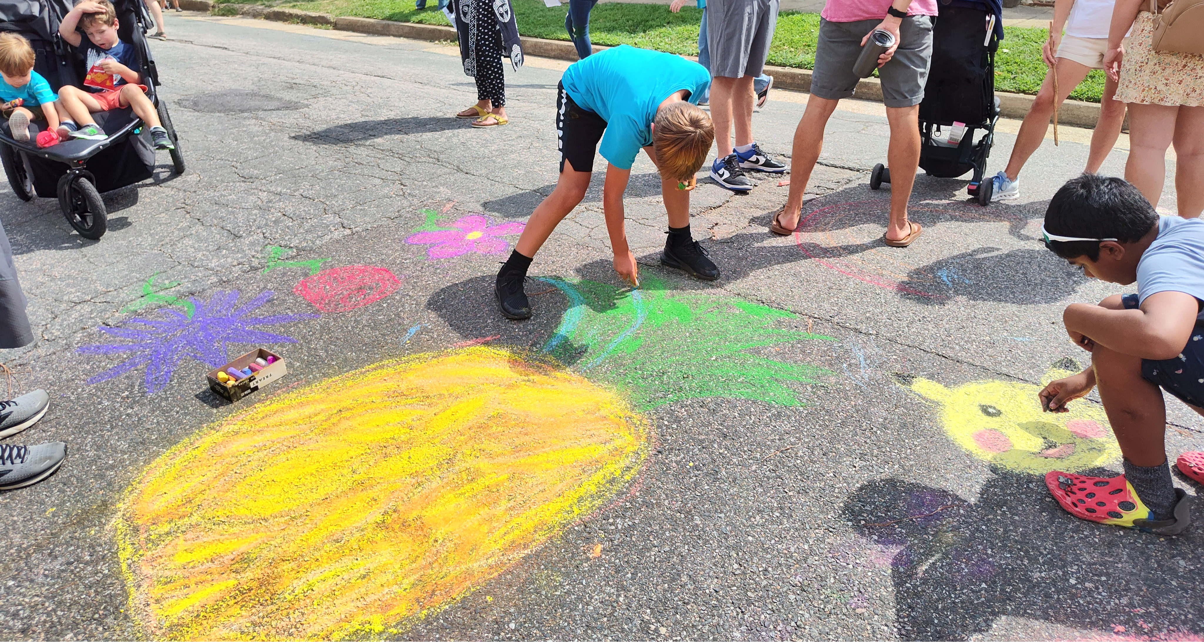 Two students drawing with chalk on the road