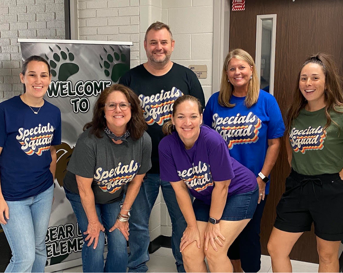 group of teachers posing in school hallway