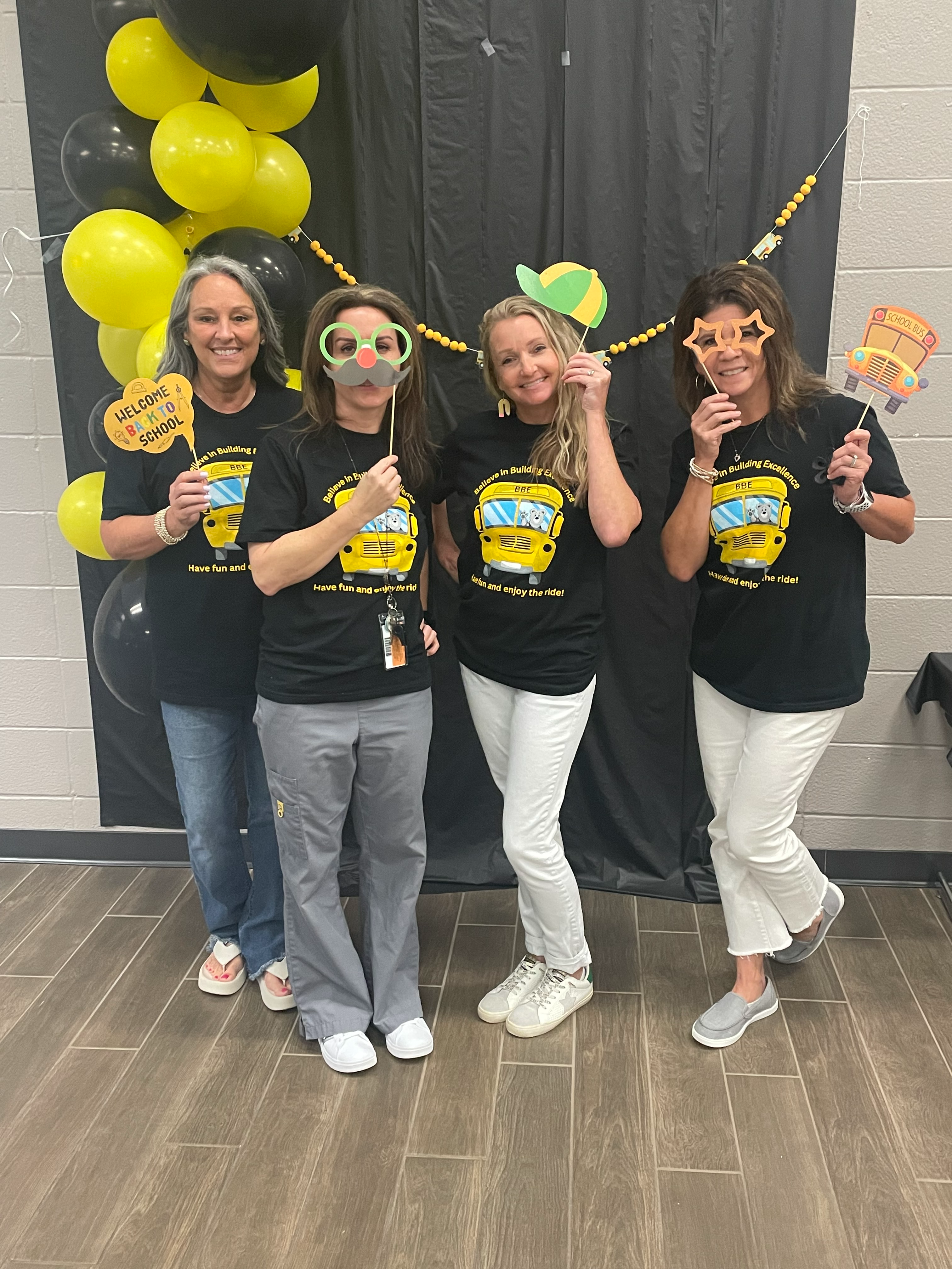 group of ladies in green shirts posing with cartoon bear