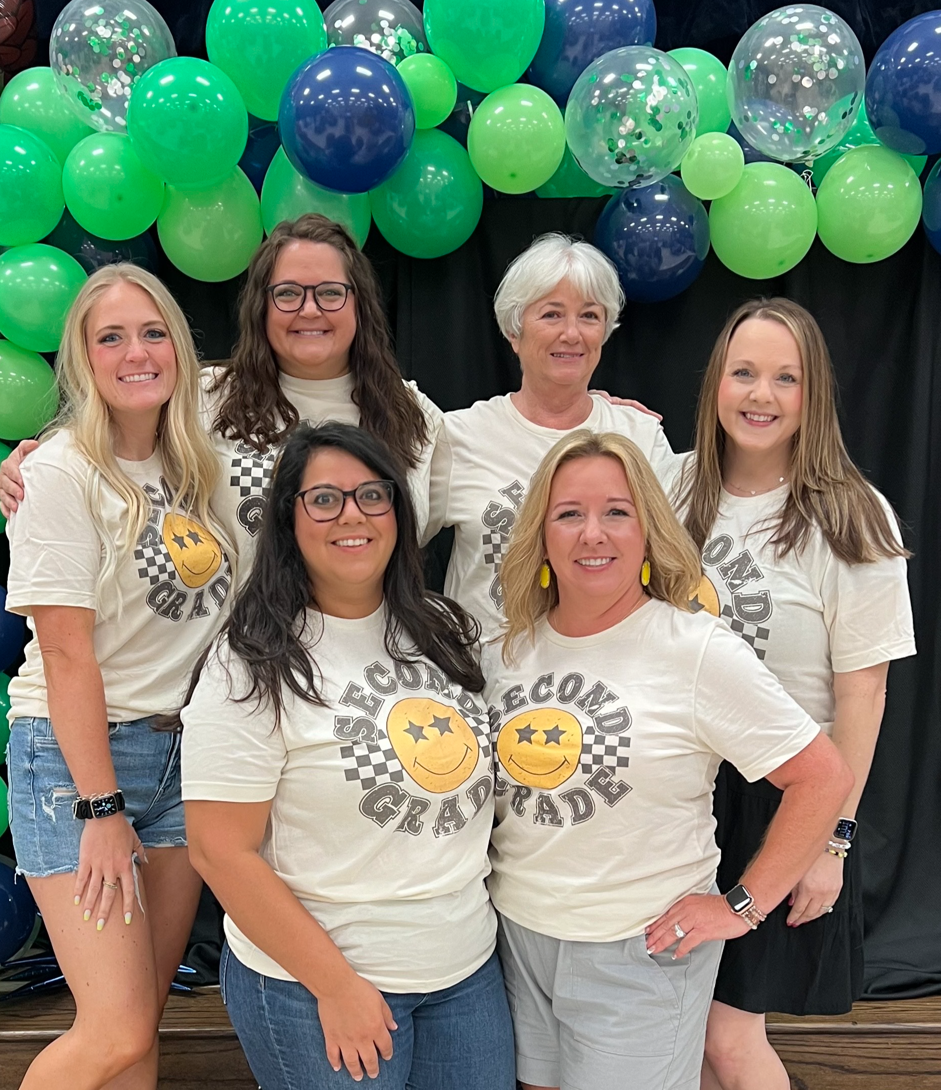 Second Grade teachers in black shirts standing posing in hallway