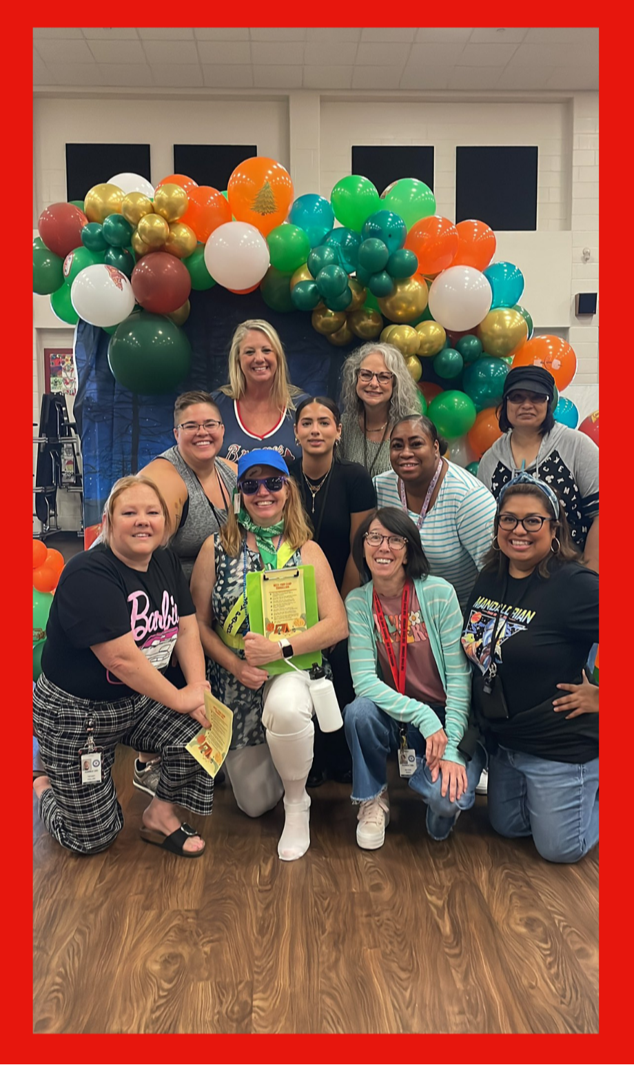 group of 10 people posing under balloons