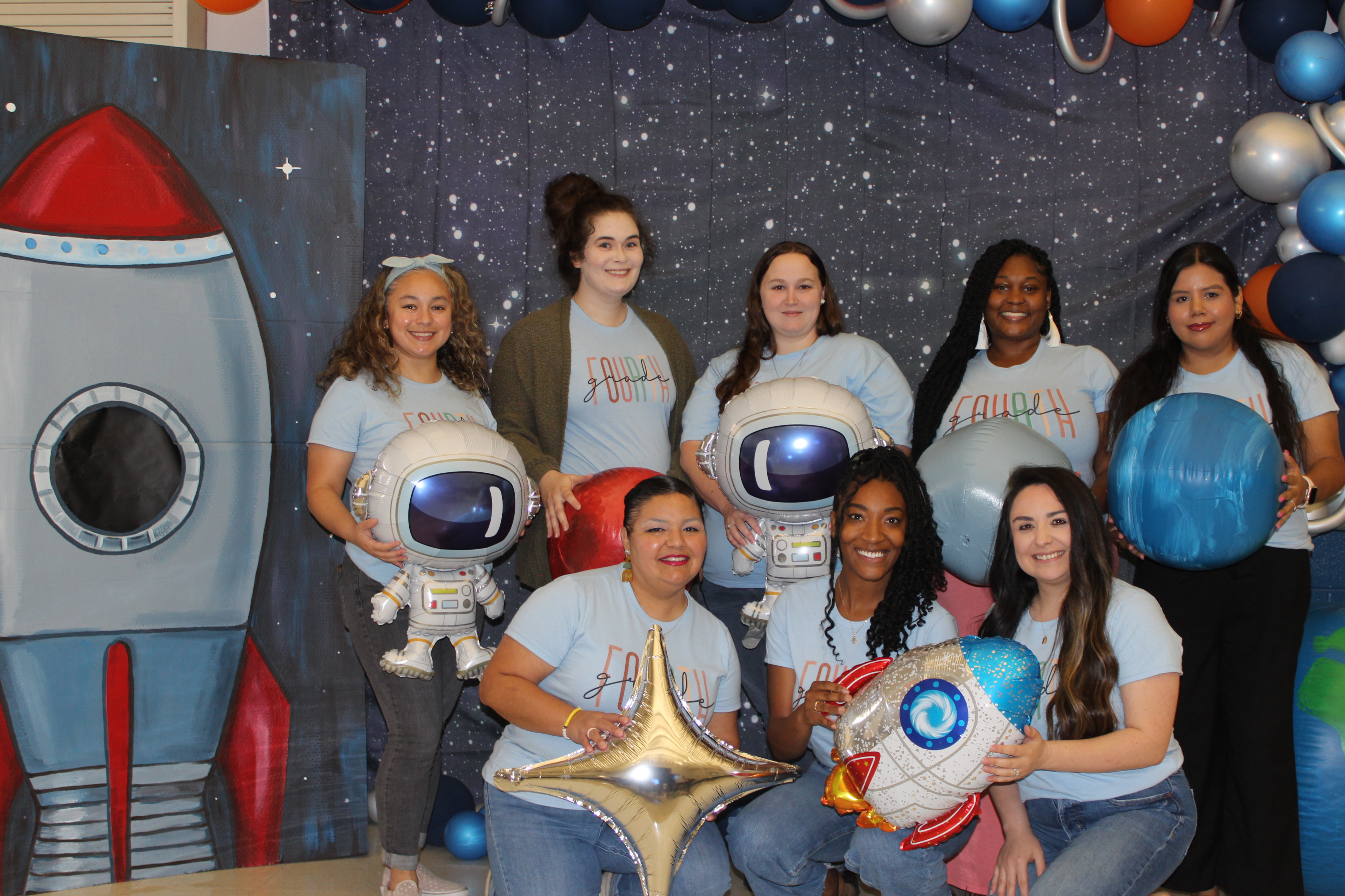 Fourth Grade teachers posing with space themed items