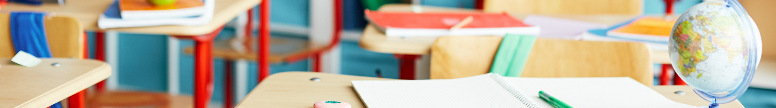 student desks with notebooks and world globe