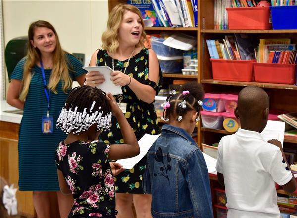 Teacher giving instructions to her students in class