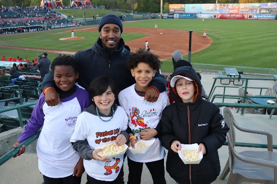 Image of a mentor with four students at a baseball game