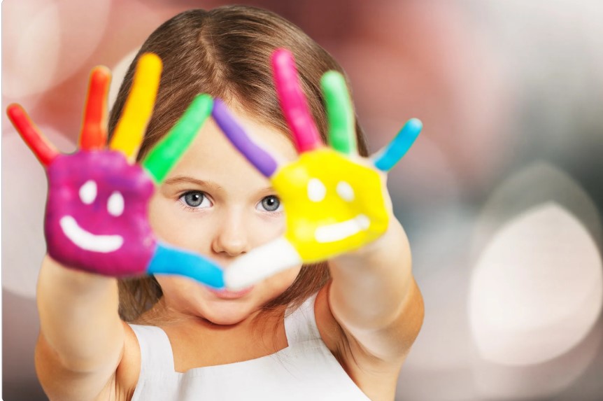 Image of little girl holding up her multi colored painted hands