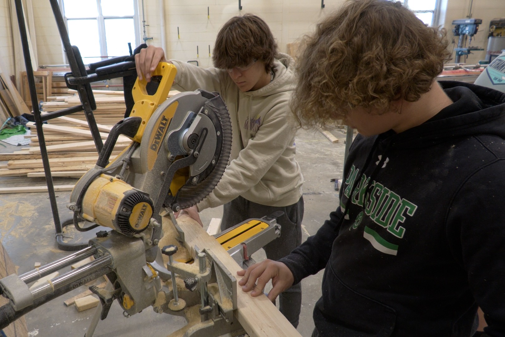 Image of two students using a table saw in the Carpentry class