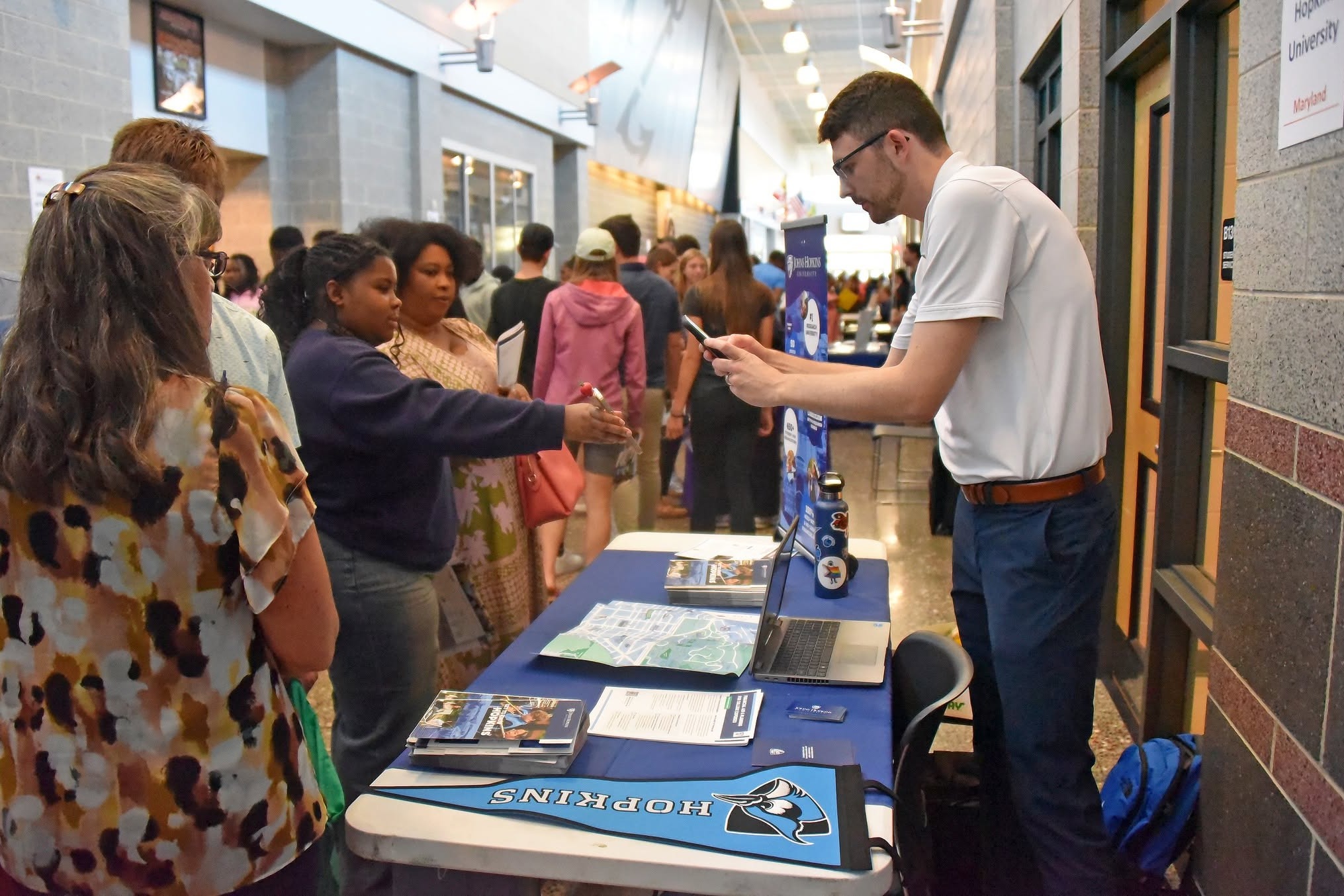 Image of students and parents talking with a college counselor during College Fair night