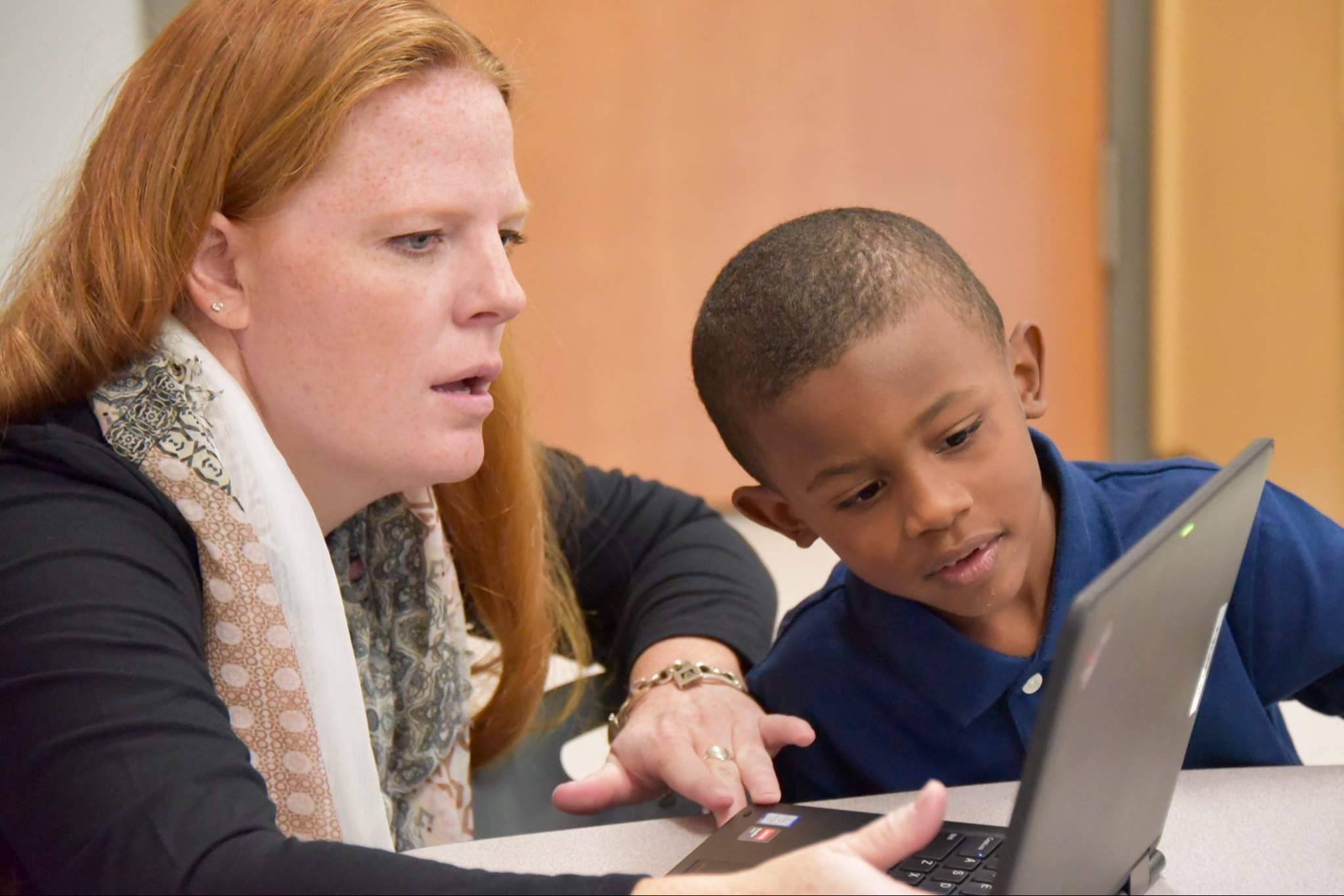 Image of teacher showing a student a lesson on the computer