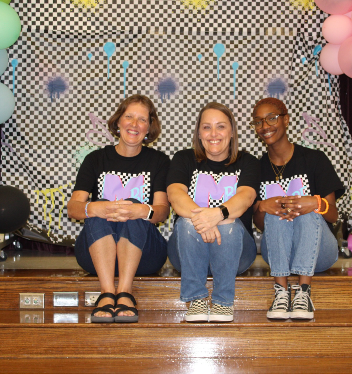 Kindergarten teachers in white shirts sitting posing in classroom