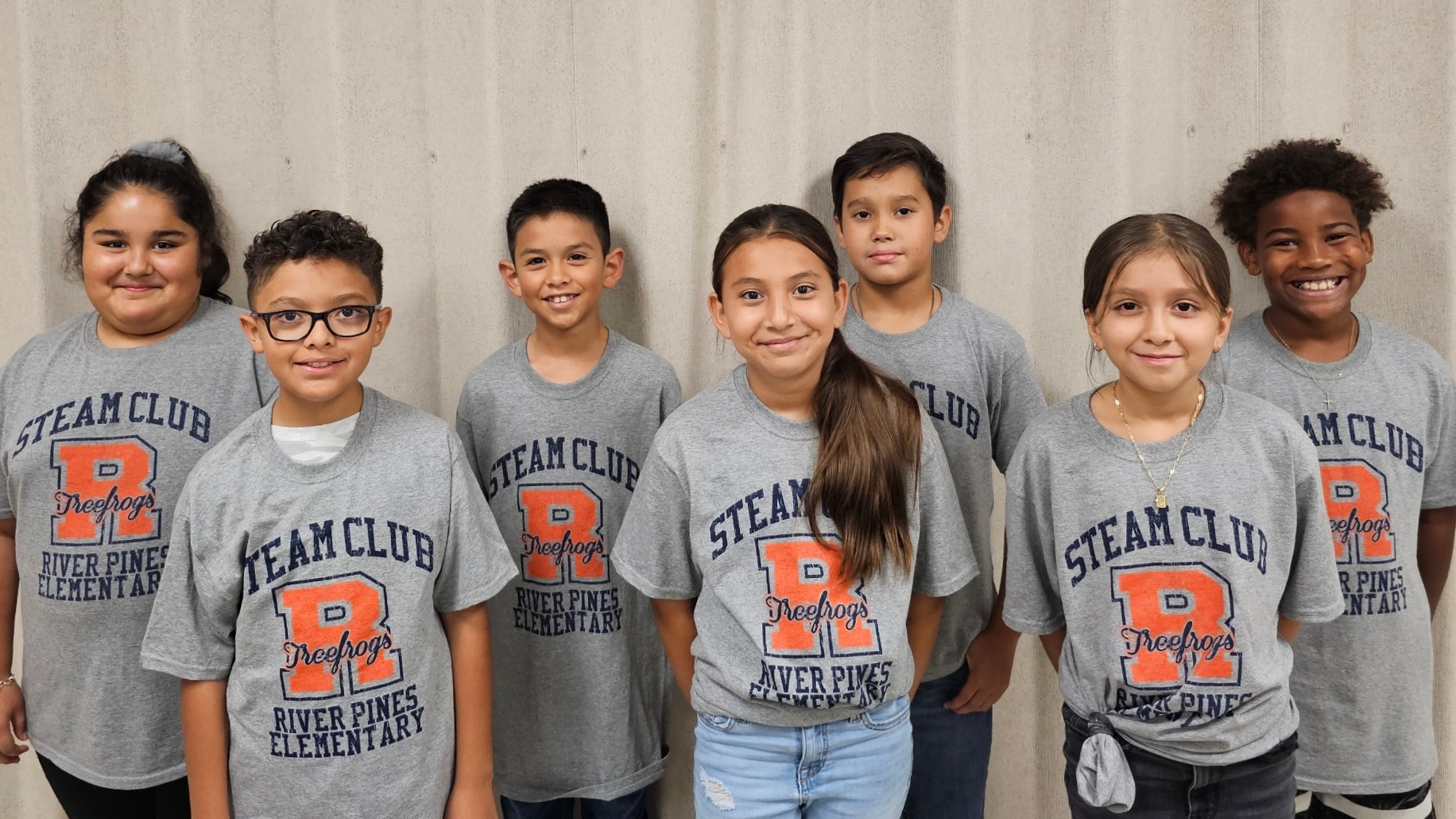 students posing with gray steam club shirts