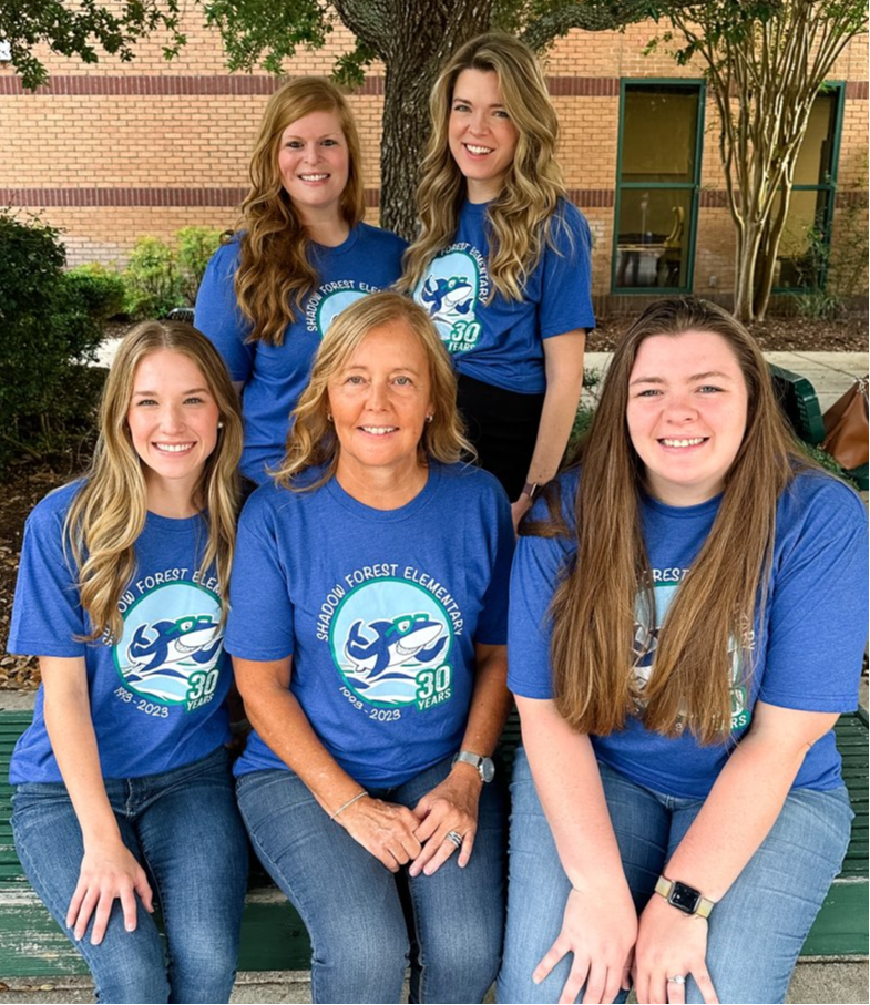 group of teachers posing outside in front of tree