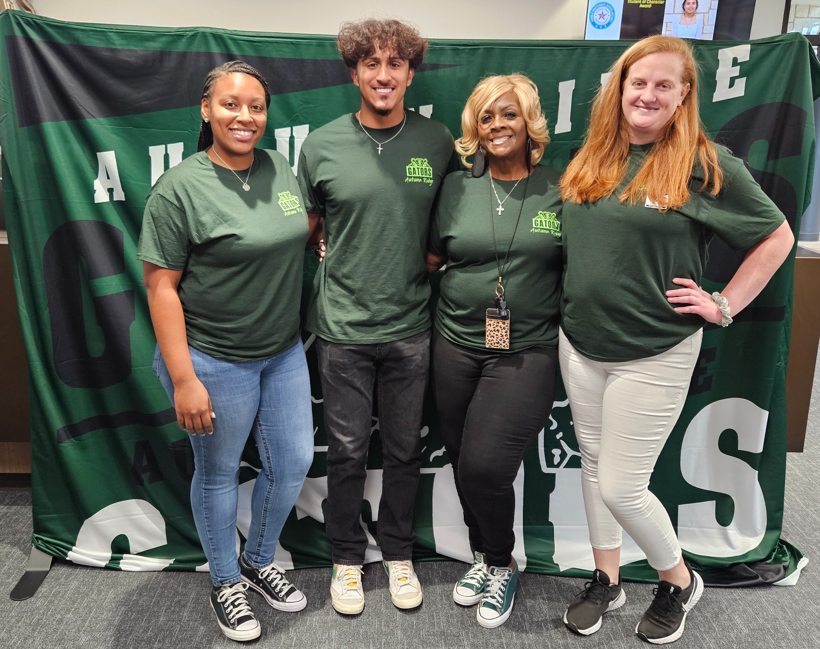 group of people standing posing in green shirts