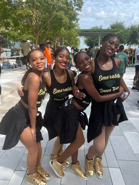 group of students in black tank tops posing outside