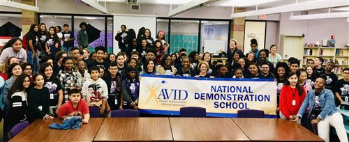 group of students posing with banner