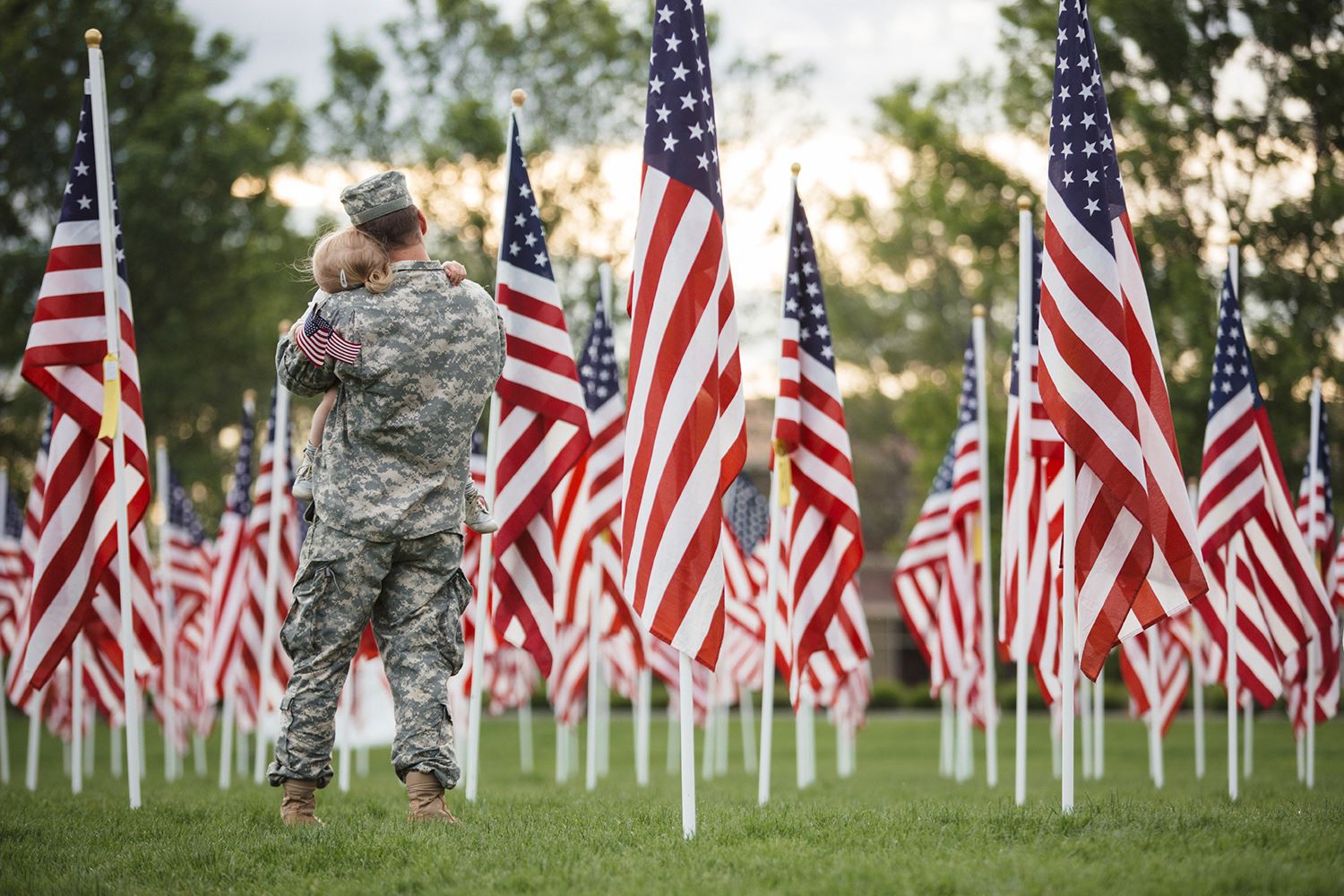 military parent with child and american flags