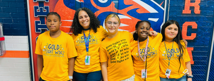 A group of student wearing a yellow shirt for the gold fight win day.
