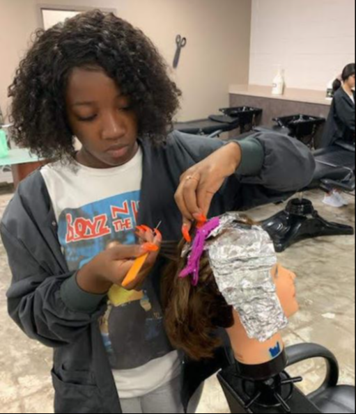 woman coloring hair on mannequin