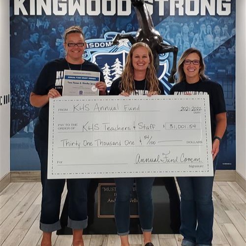 group of people standing posing with oversized check