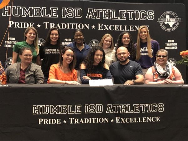 group of people posing behind signing table for Humble ISD athletics